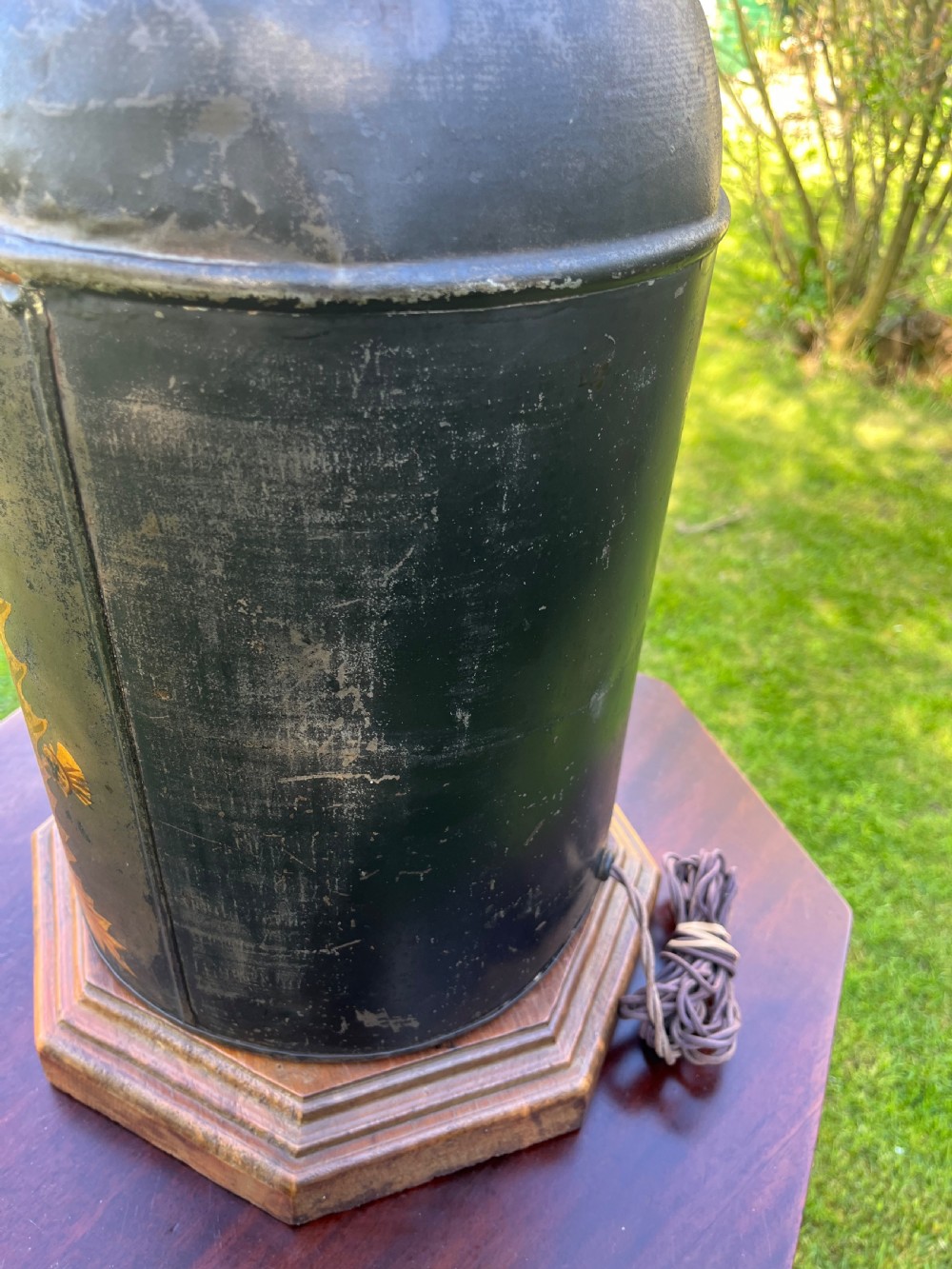 An antique dark metal tea canister converted into a table lamp, decorated with a hand-painted scene depicting Craigellachie Bridge set on a wooden base. View IX