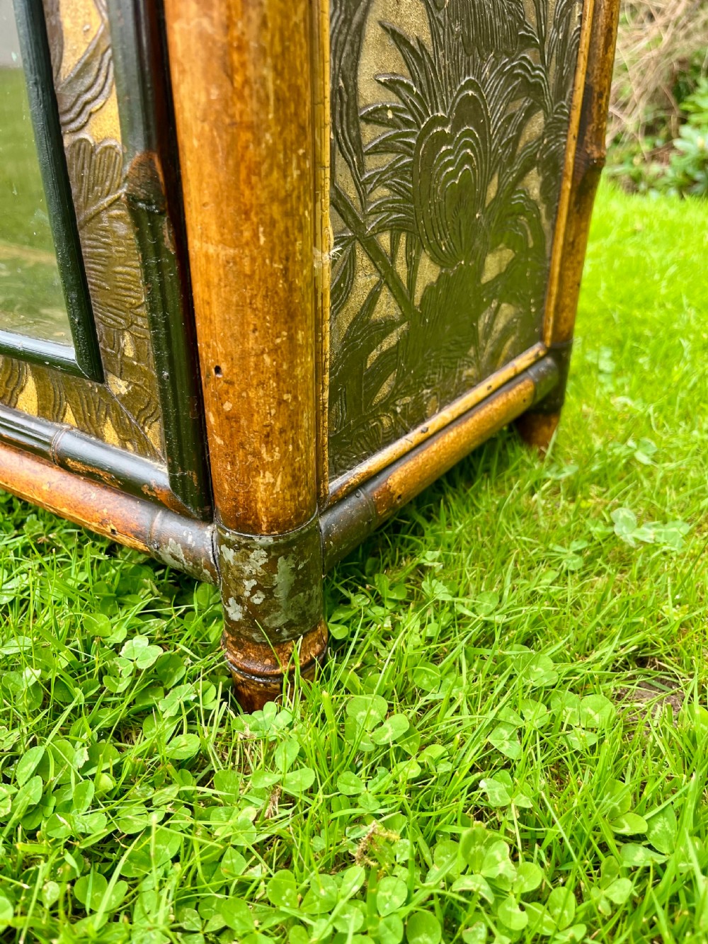 A late Victorian bamboo display cabinet with two glazed doors, upper drawers, and dark embossed botanical pattern panels. View XIV