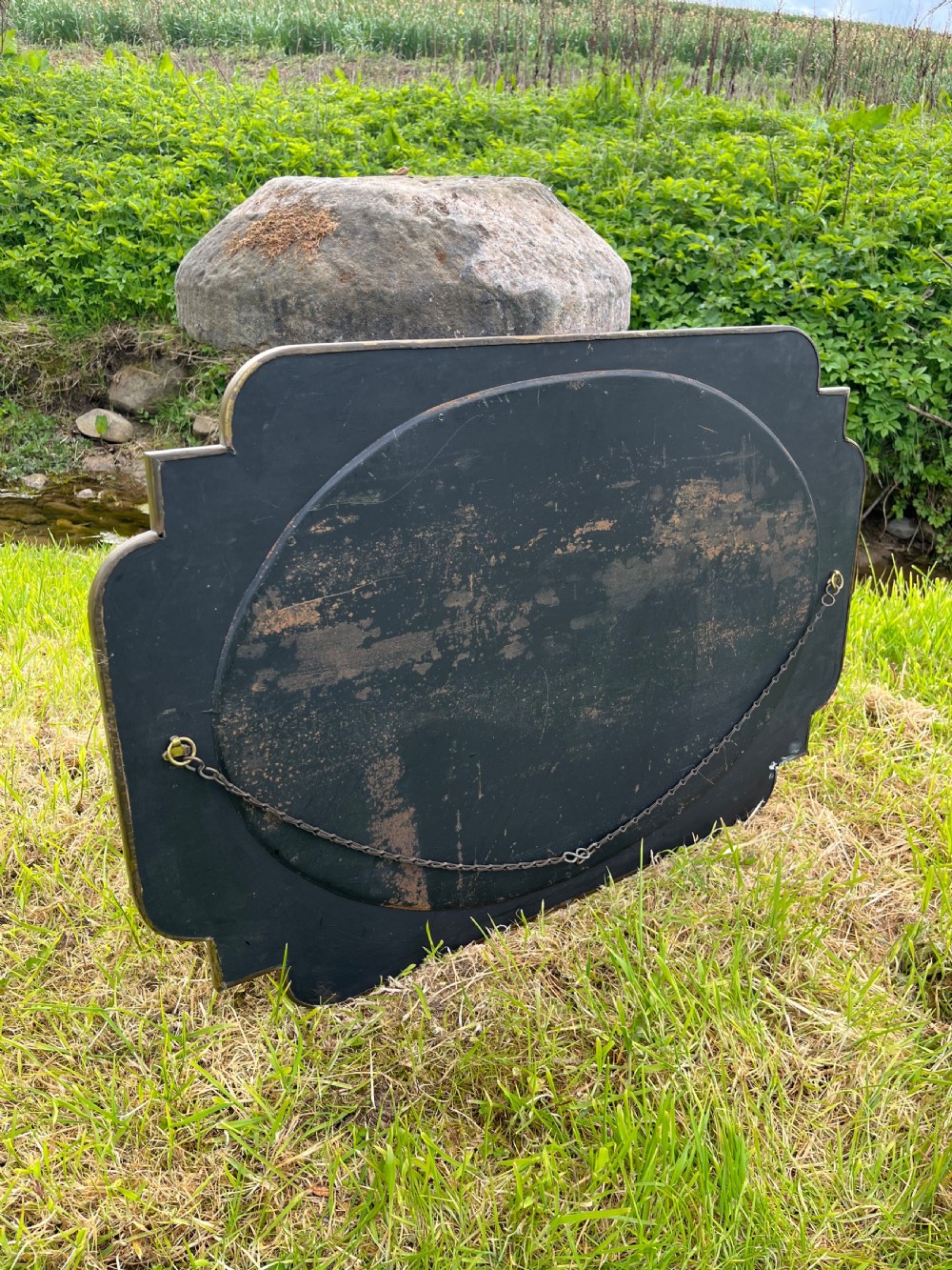 A large shaped brass wall mirror featuring an oval glass centre enclosed by relief Celtic knotwork and leaf motifs. View VIII