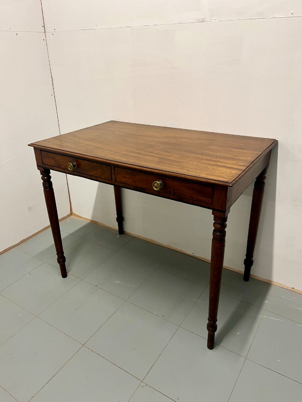A Scottish Regency mahogany side table featuring two frieze drawers with brass handles and slender turned legs. View II