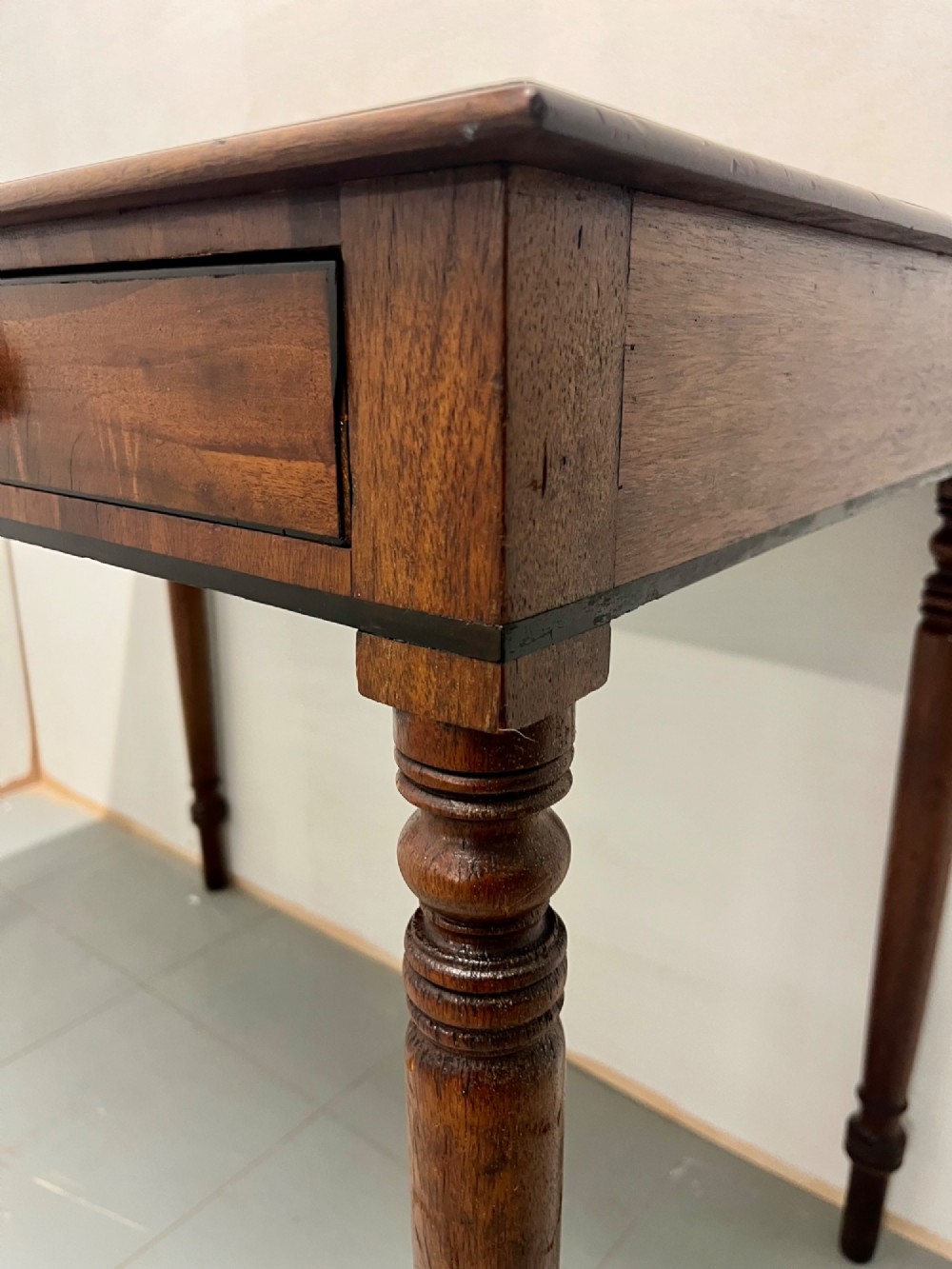 A Scottish Regency mahogany side table featuring two frieze drawers with brass handles and slender turned legs. View IV