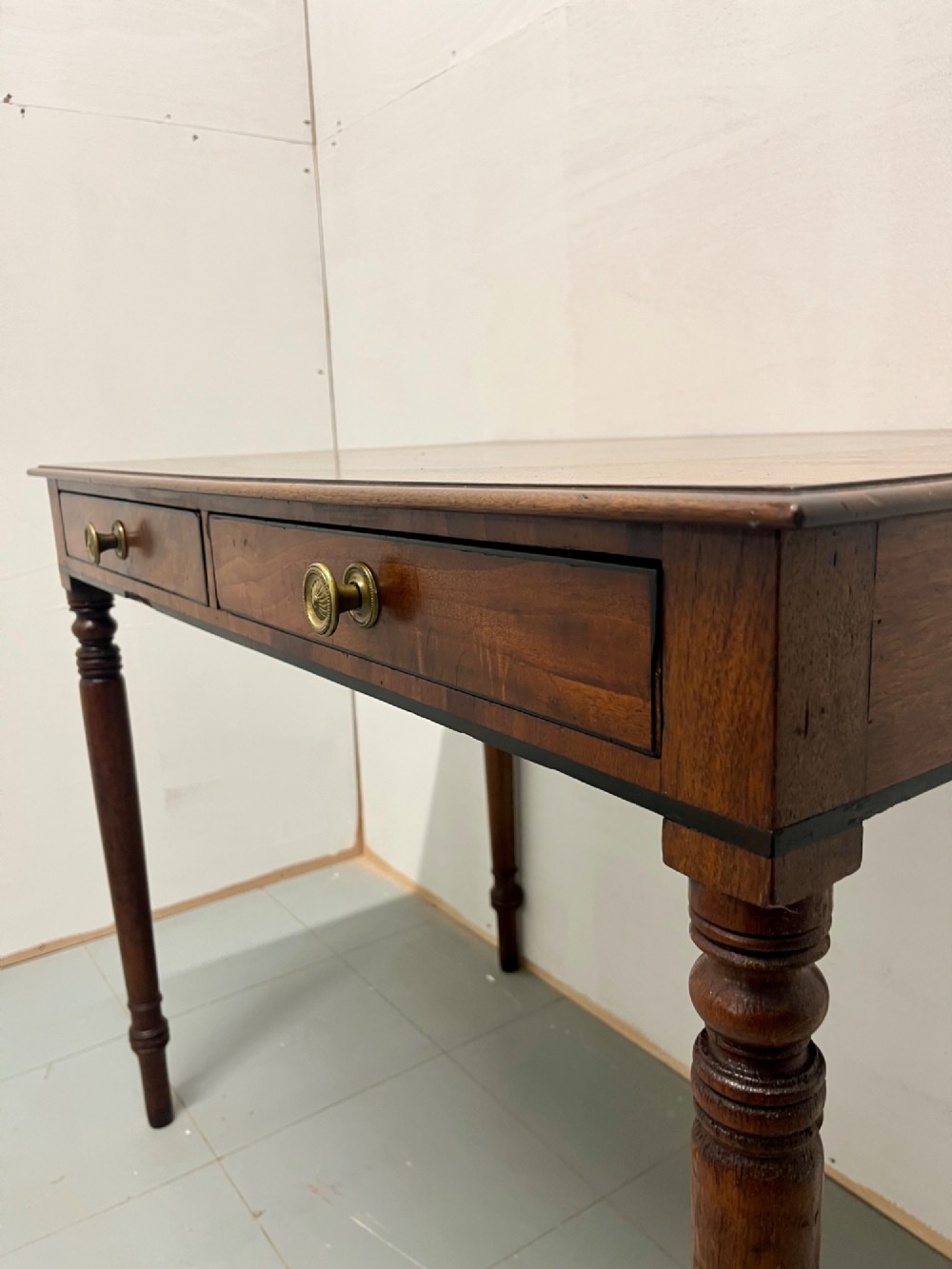A Scottish Regency mahogany side table featuring two frieze drawers with brass handles and slender turned legs. View VI
