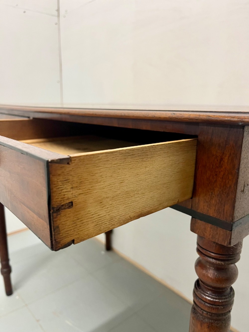 A Scottish Regency mahogany side table featuring two frieze drawers with brass handles and slender turned legs. View VII