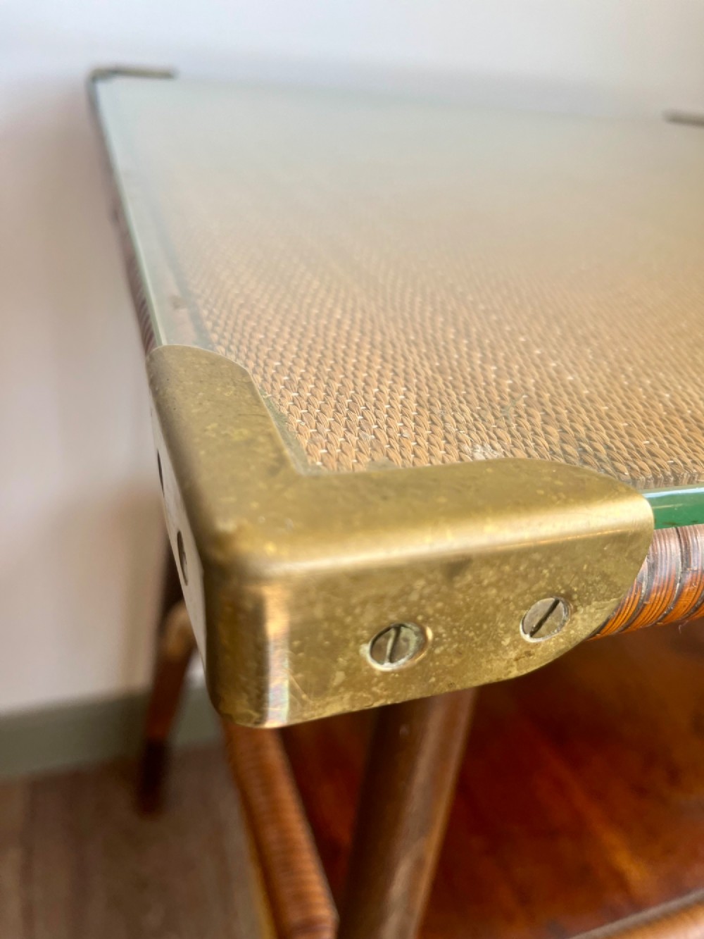 A square two-tier Dryad cane occasional table with a clear glass top, brass corner mounts, dark wood lower shelf, and woven tapered legs. View IV