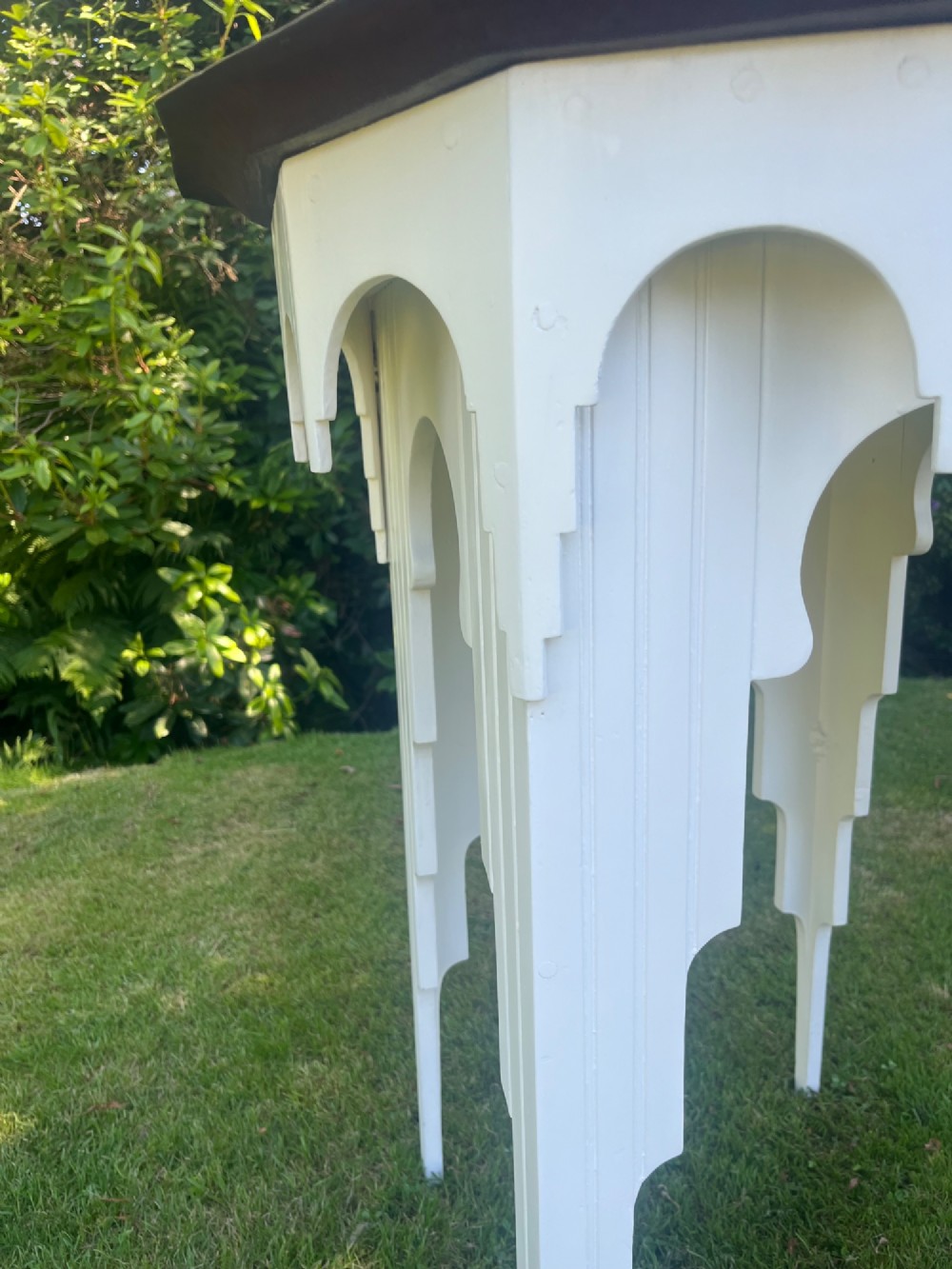 A white painted Moorish style occasional table featuring stepped horseshoe arches and a dark contrasting tray top. View II