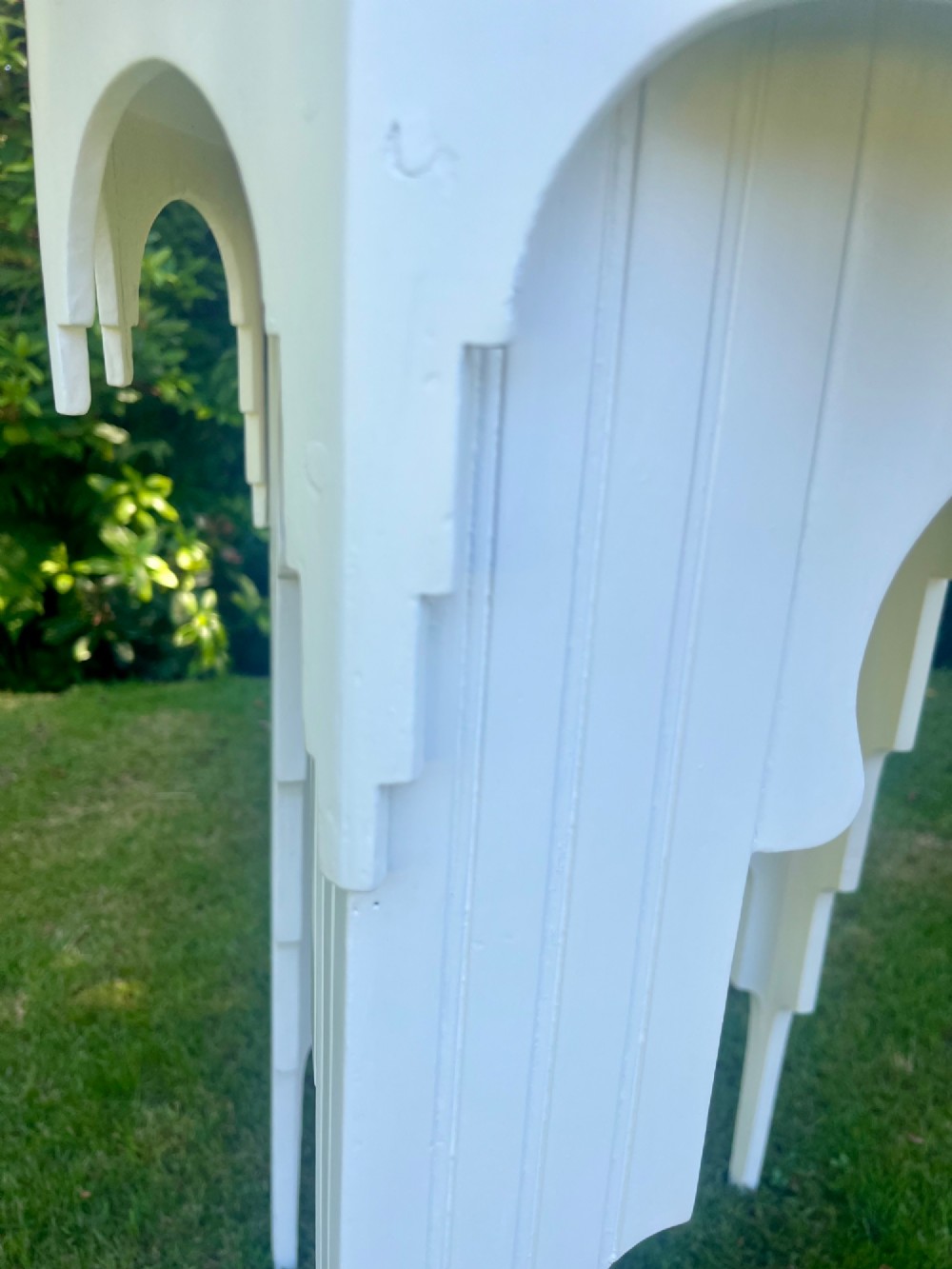 A white painted Moorish style occasional table featuring stepped horseshoe arches and a dark contrasting tray top. View III