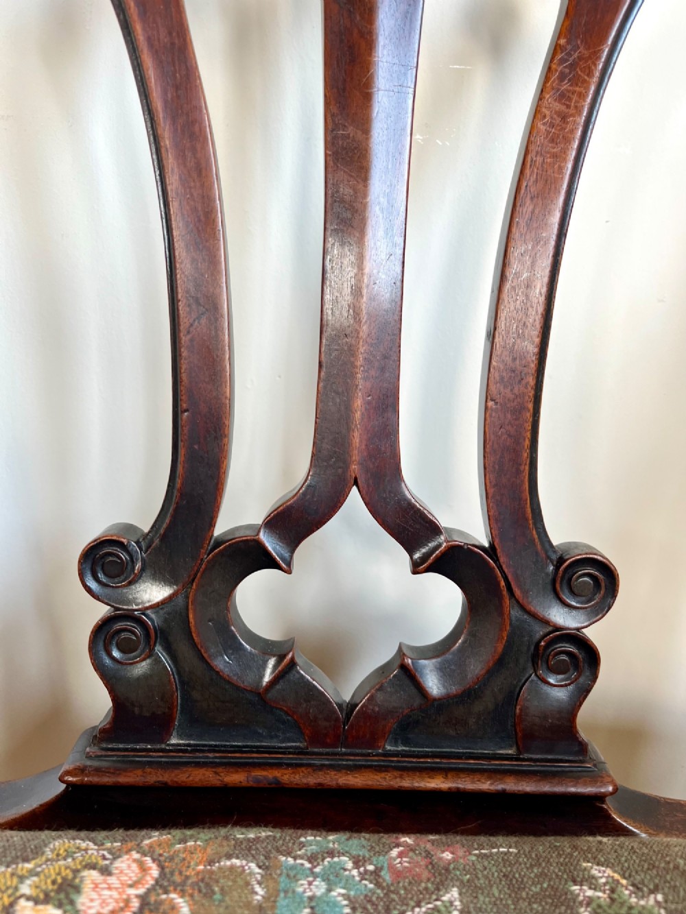 A Georgian Chippendale mahogany open armchair featuring a hand-carved pierced splat back, shaped armrests, square legs, and a floral tapestry upholstered seat. View II