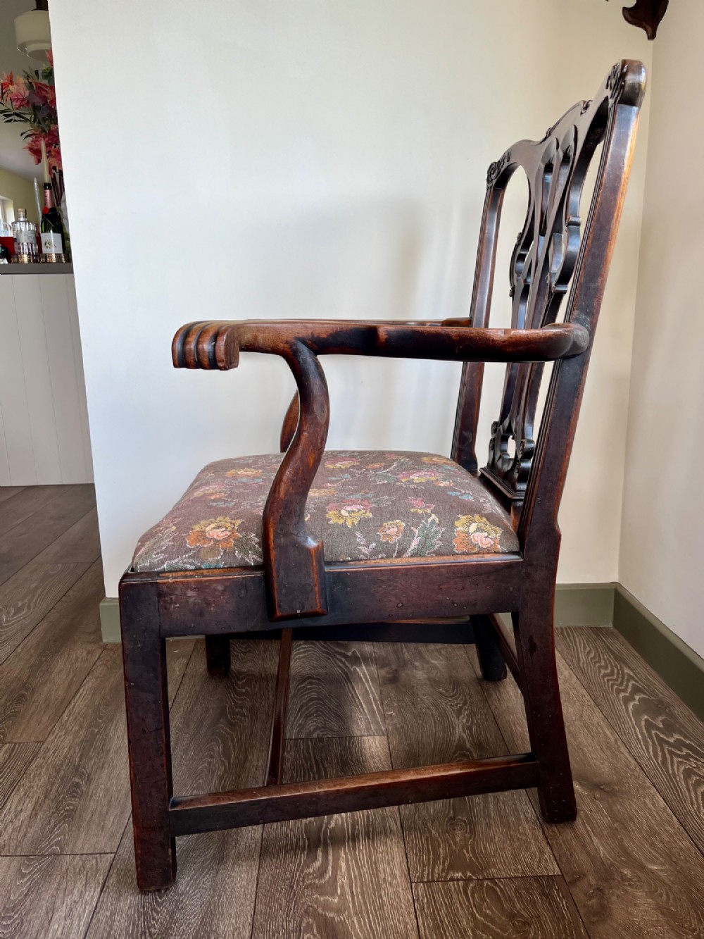 A Georgian Chippendale mahogany open armchair featuring a hand-carved pierced splat back, shaped armrests, square legs, and a floral tapestry upholstered seat. View VI