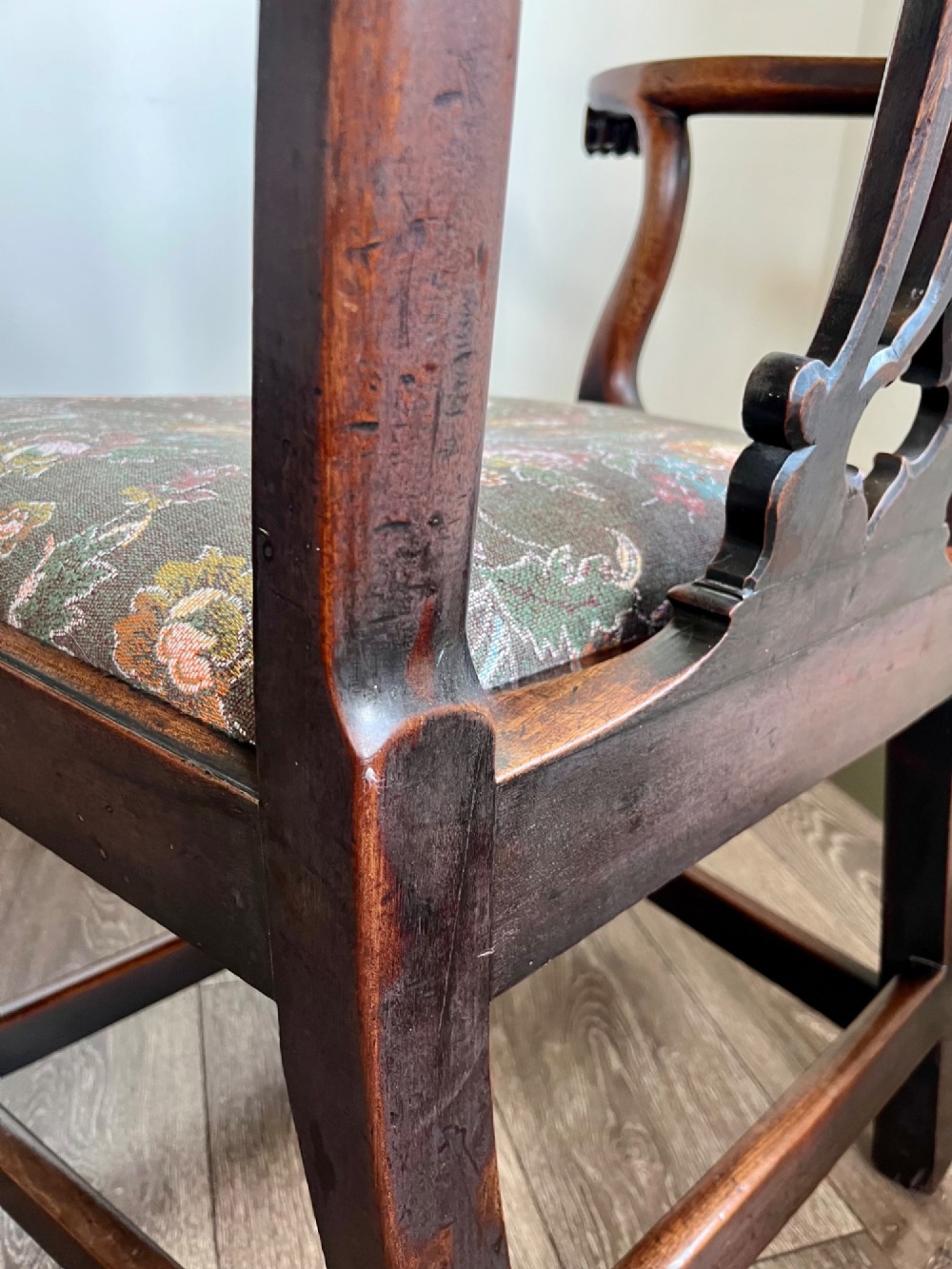 A Georgian Chippendale mahogany open armchair featuring a hand-carved pierced splat back, shaped armrests, square legs, and a floral tapestry upholstered seat. View VIII