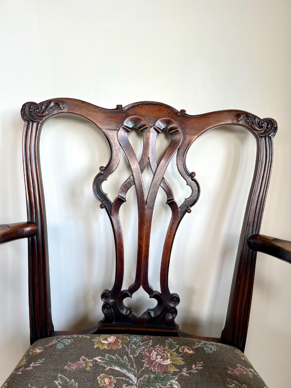 A Georgian Chippendale mahogany open armchair featuring a hand-carved pierced splat back, shaped armrests, square legs, and a floral tapestry upholstered seat. View XIV