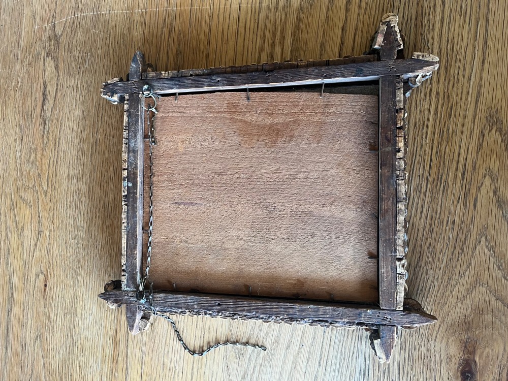 A square antique wall mirror framed with layered dark cork bark featuring intricate hand-carved rosettes and geometric notched corners surrounding foxed mirror glass. View VIII