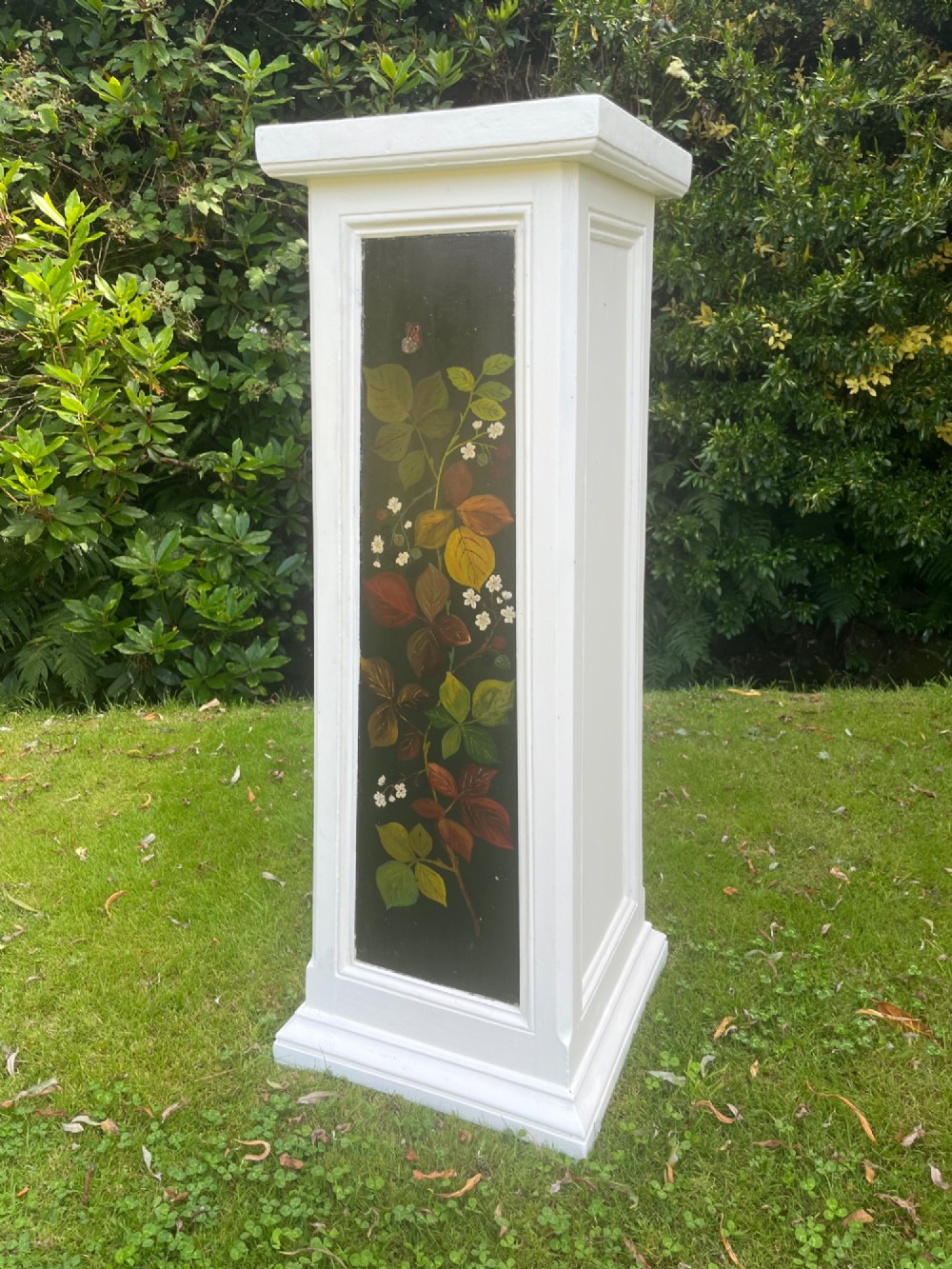 A pair of white wooden tapered display pedestals with inset black panels decorated with hand-painted floral and botanical foliage designs. View VIII