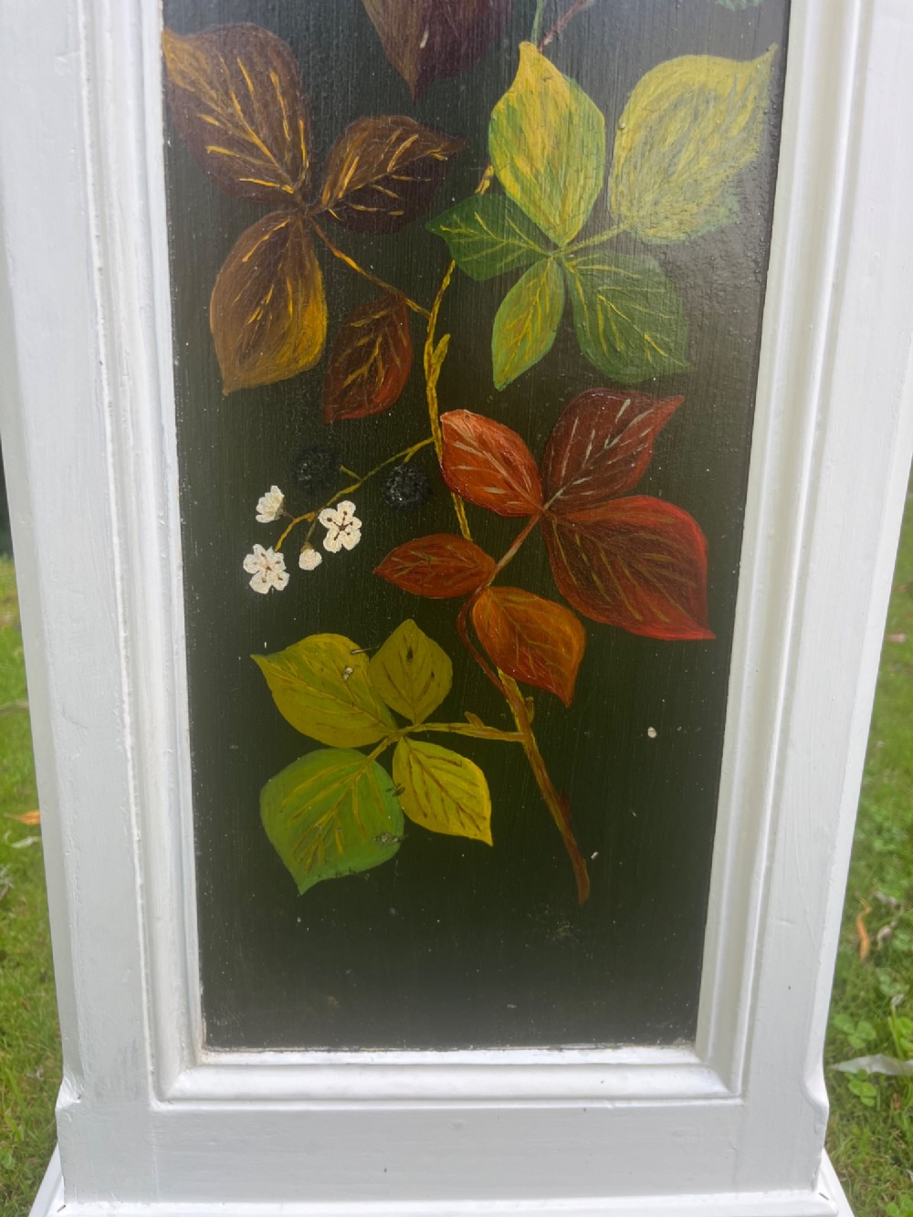 A pair of white wooden tapered display pedestals with inset black panels decorated with hand-painted floral and botanical foliage designs. View XI