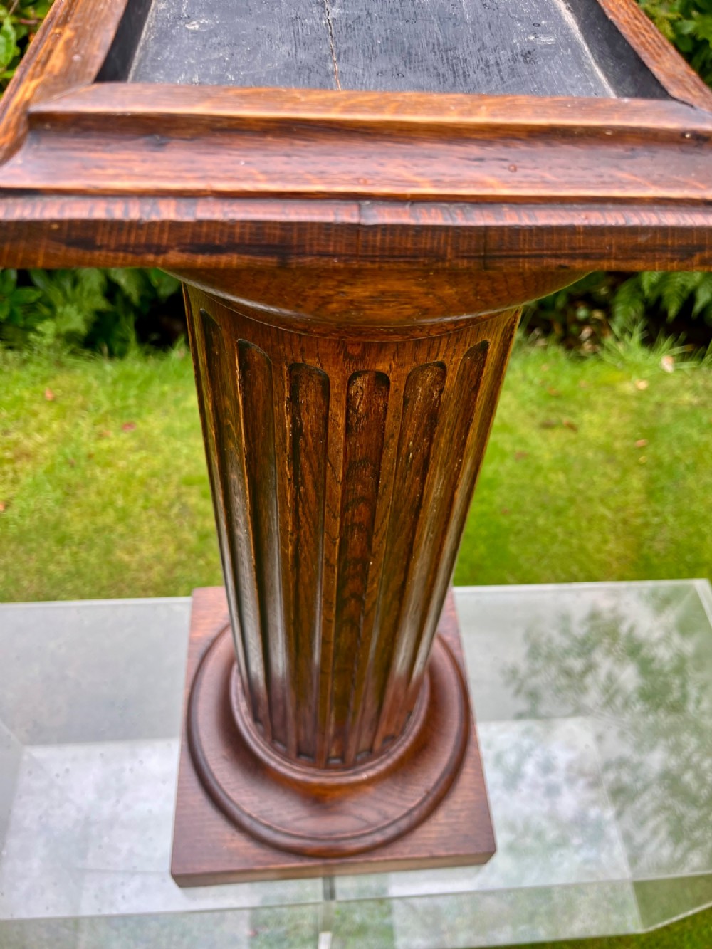 A carved oak pedestal stand featuring a fluted central column, moulded capital, and a square stepped base. View VI