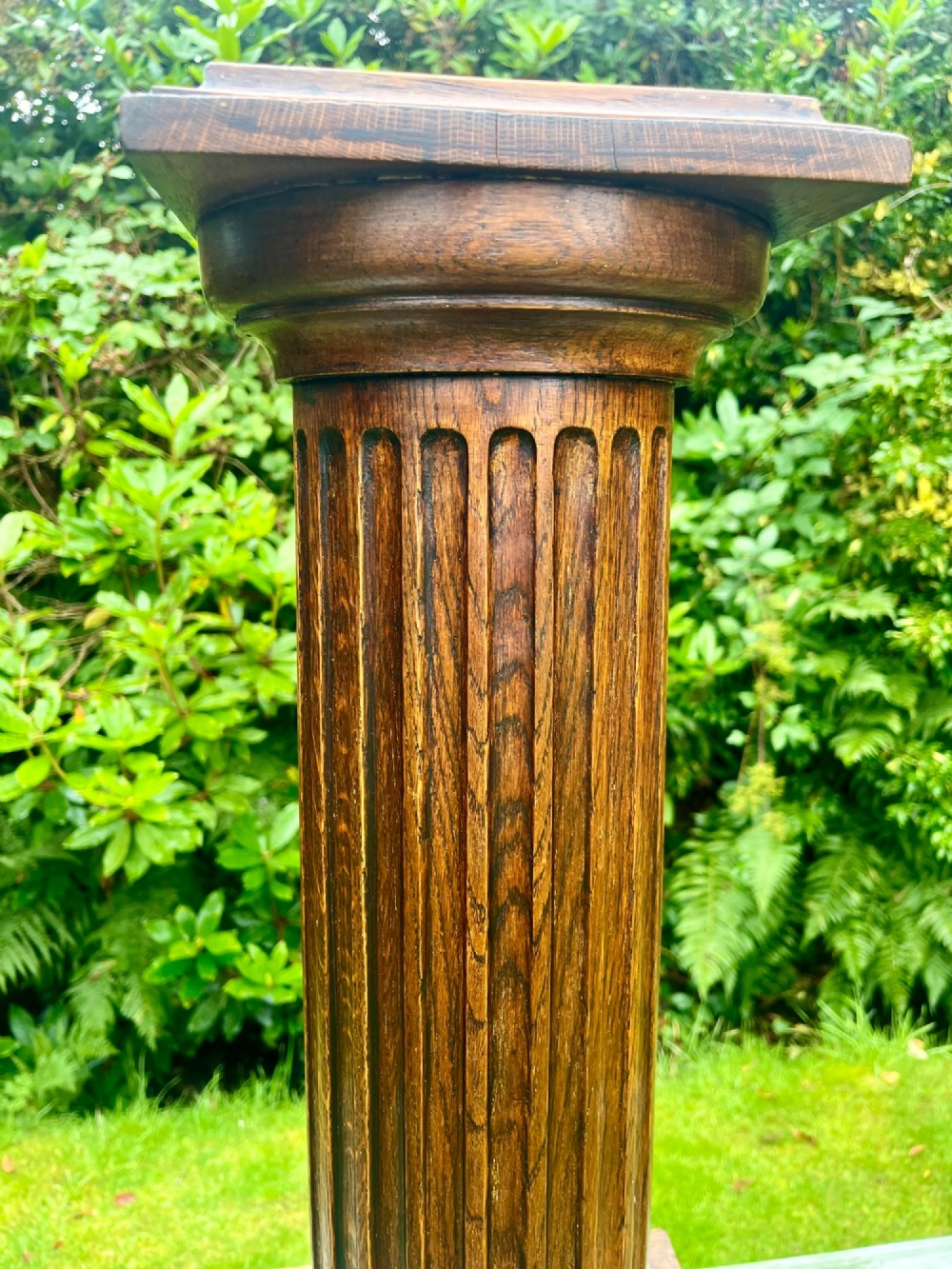A carved oak pedestal stand featuring a fluted central column, moulded capital, and a square stepped base. View VIII