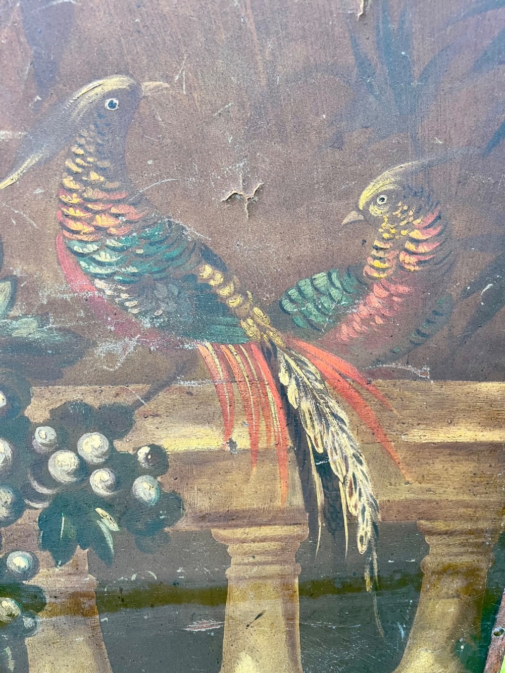 A three-panel antique folding leather screen hand-painted with a central urn of flowers, fruit, and exotic birds against a warm brown background. View VI