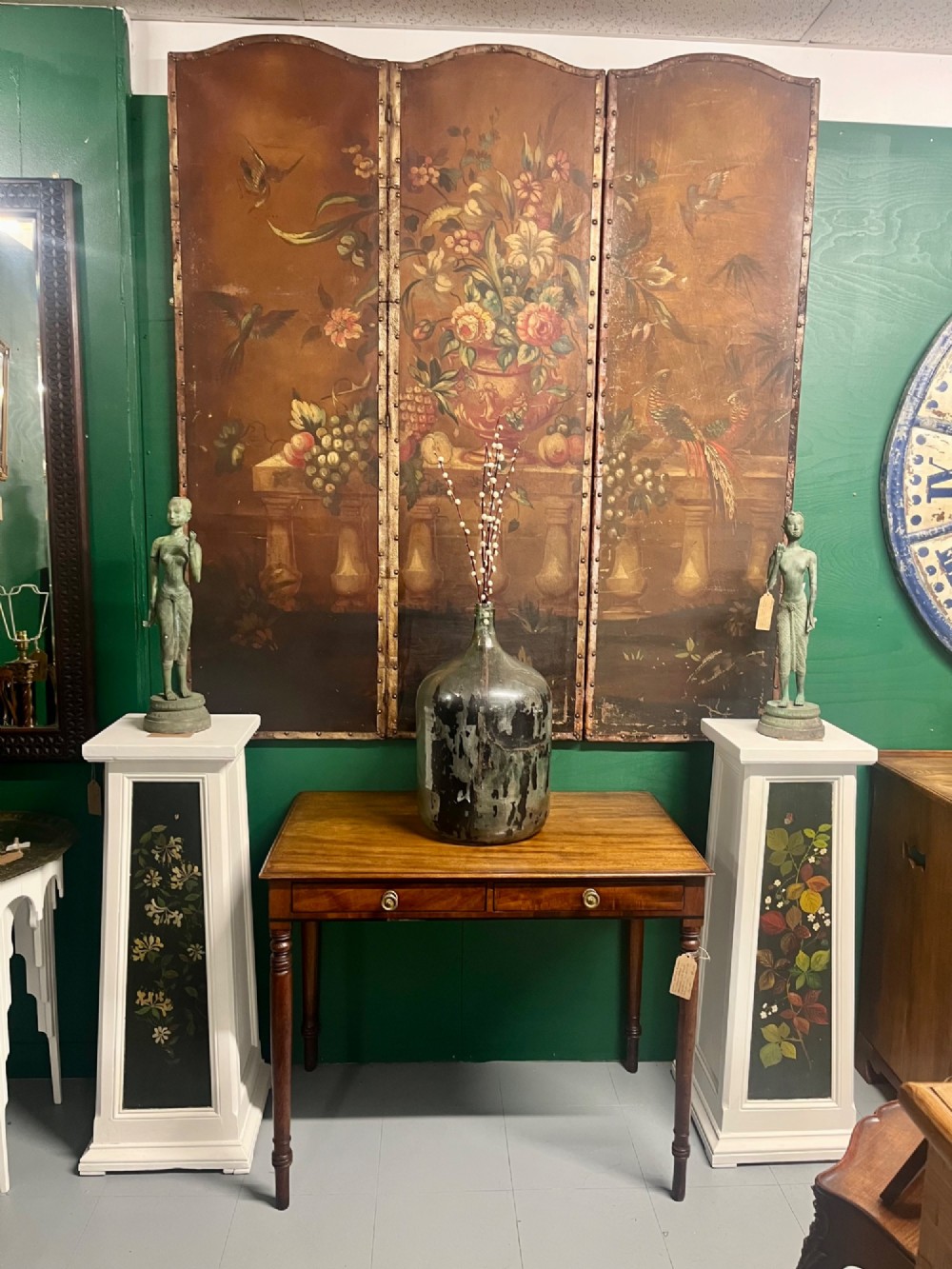 A three-panel antique folding leather screen hand-painted with a central urn of flowers, fruit, and exotic birds against a warm brown background. View XI