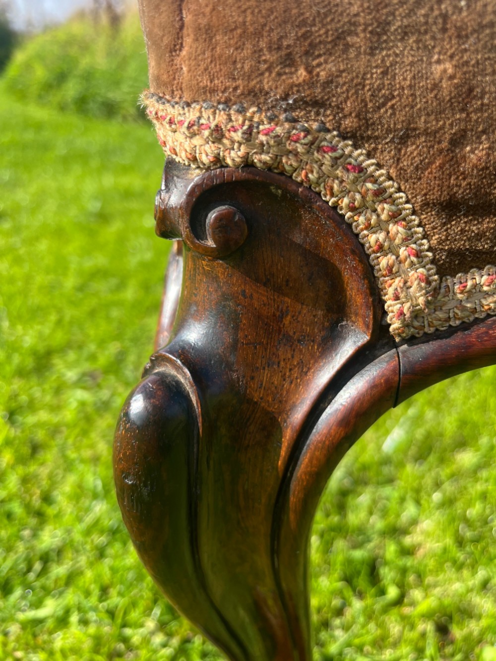 A long rectangular Victorian centre stool with dark rosewood cabriole legs and floral tapestry upholstery set in brown velvet. View VIII