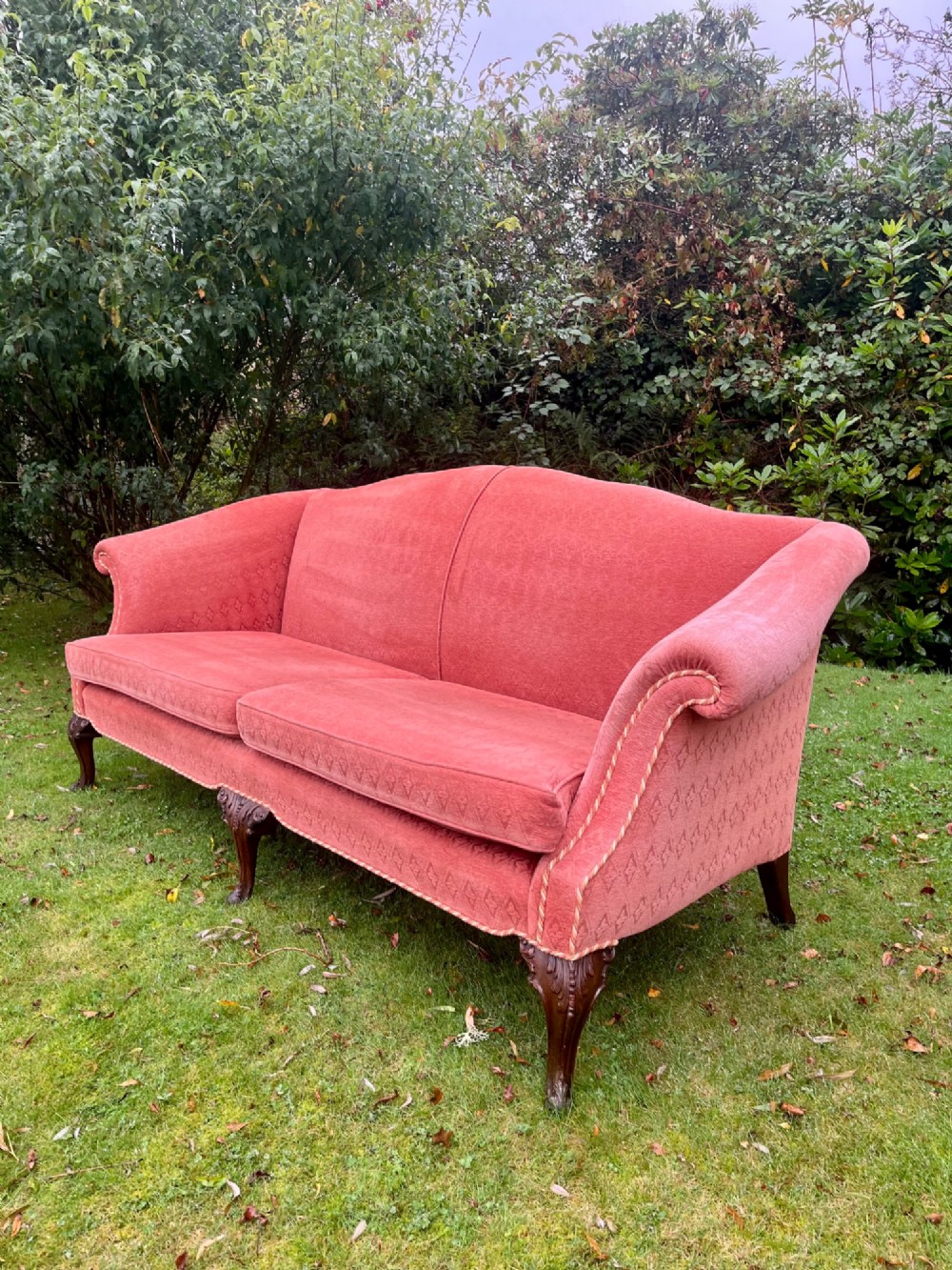 A terracotta upholstered camel back sofa featuring carved mahogany cabriole legs and twin seat cushions. View II
