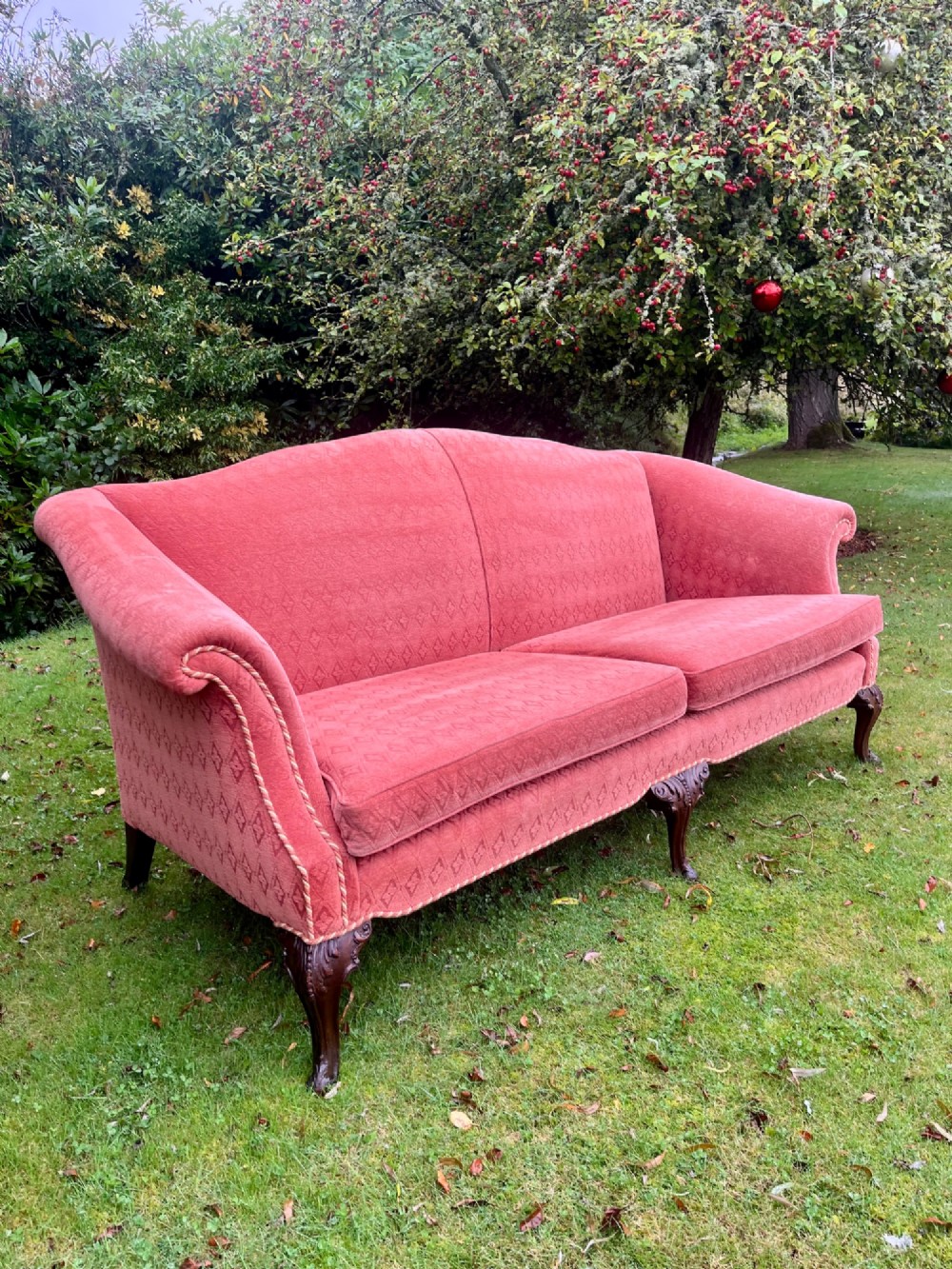 A terracotta upholstered camel back sofa featuring carved mahogany cabriole legs and twin seat cushions. View VI