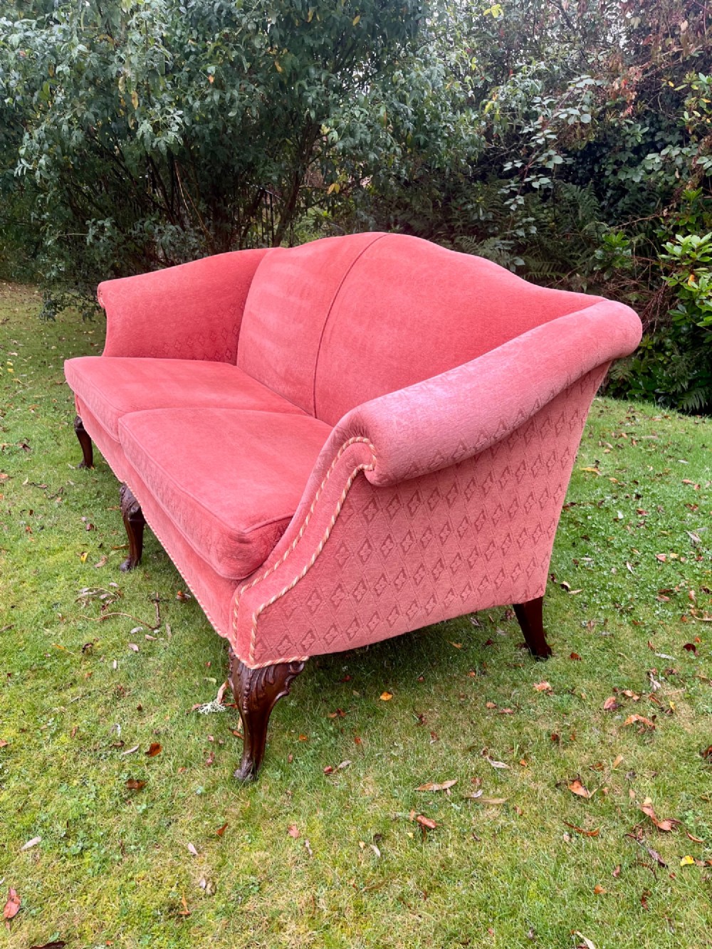 A terracotta upholstered camel back sofa featuring carved mahogany cabriole legs and twin seat cushions. View IX