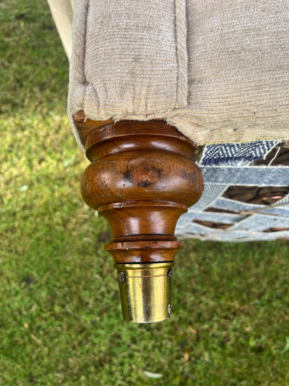 A Victorian style deep-seated sofa featuring button-tufted back upholstery in light beige fabric with turned wooden front legs. View VIII