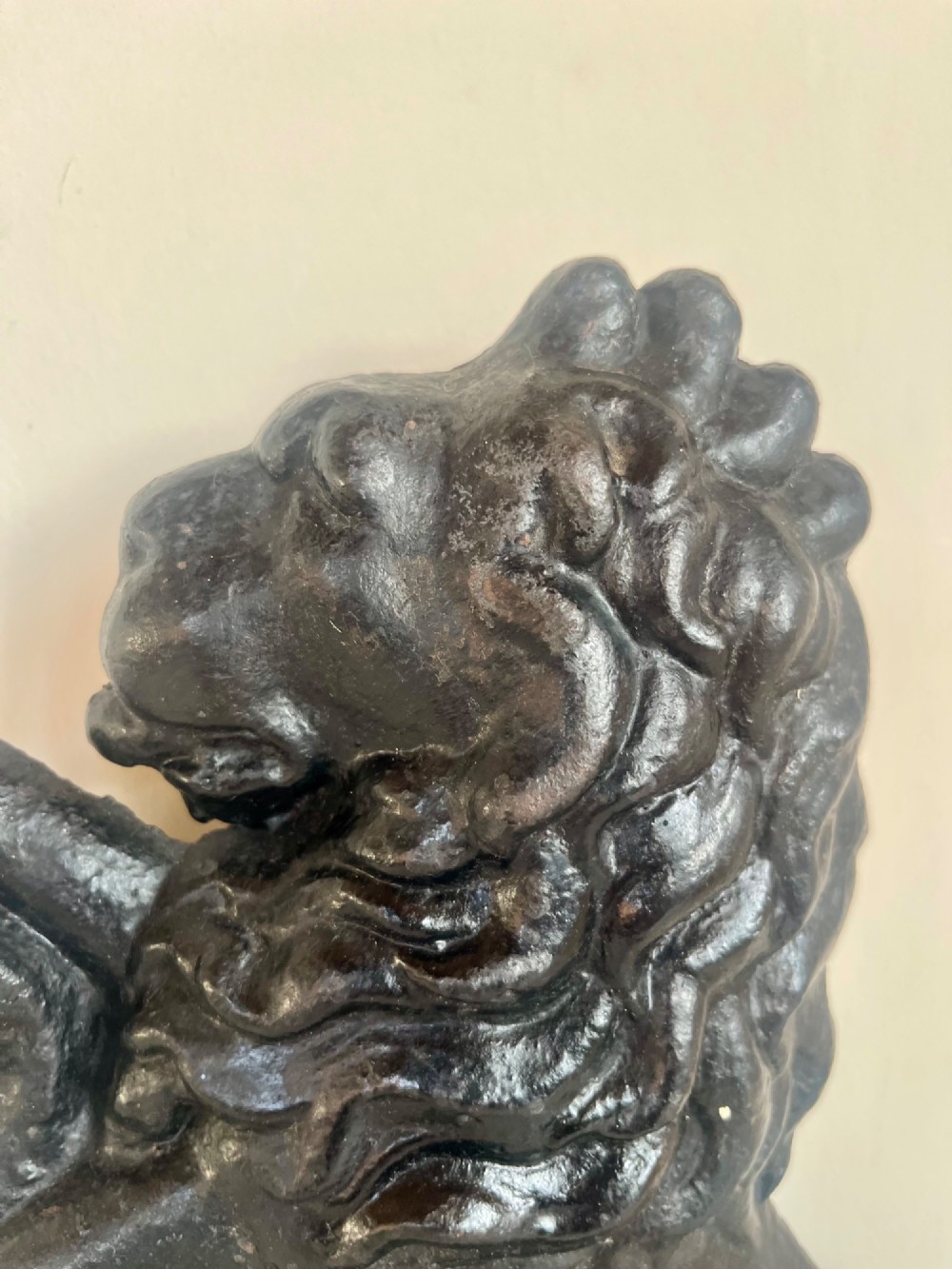 A heavy black cast iron door porter depicting a heraldic lion rampant on a stepped rectangular plinth base. View III