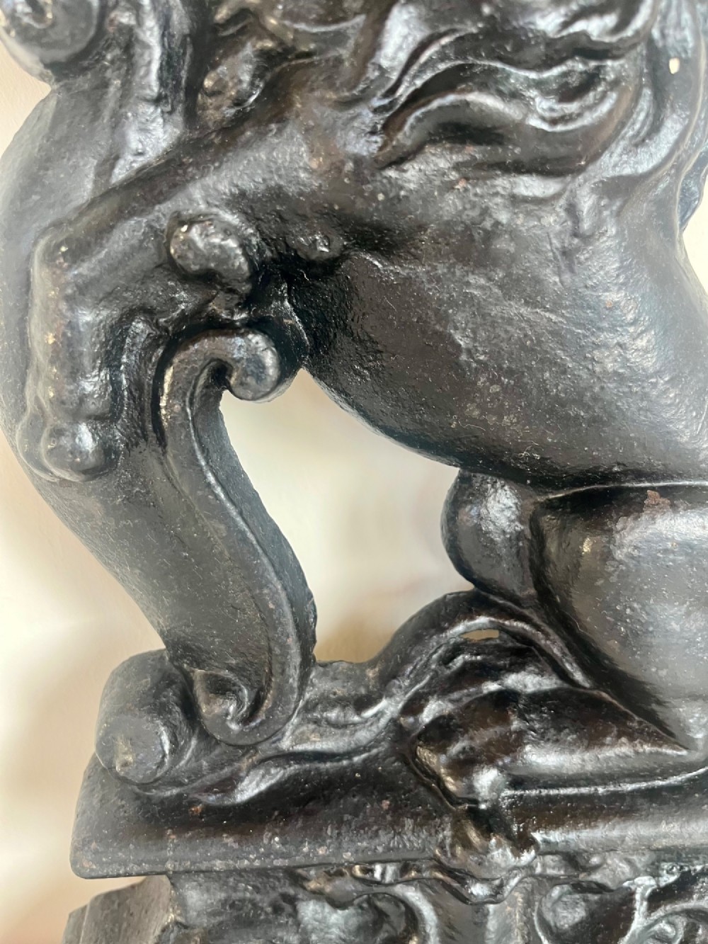 A heavy black cast iron door porter depicting a heraldic lion rampant on a stepped rectangular plinth base. View VI