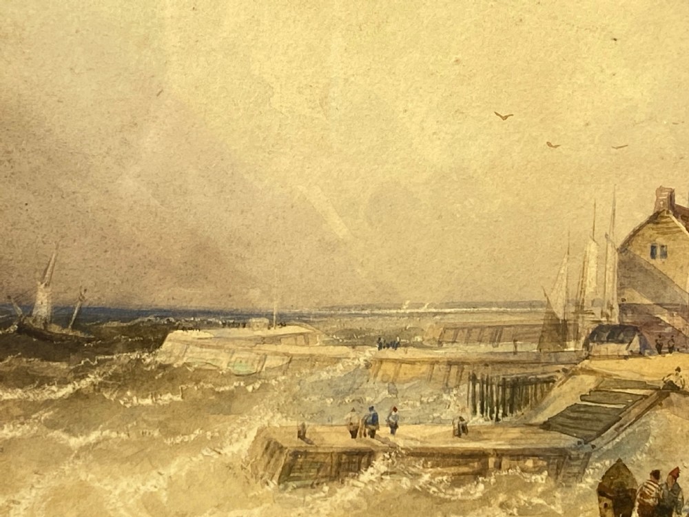 A 19th-century watercolour painting depicting a coastal town and harbour scene with rough seas, set inside a heavy gold gilt scrollwork frame. View IV
