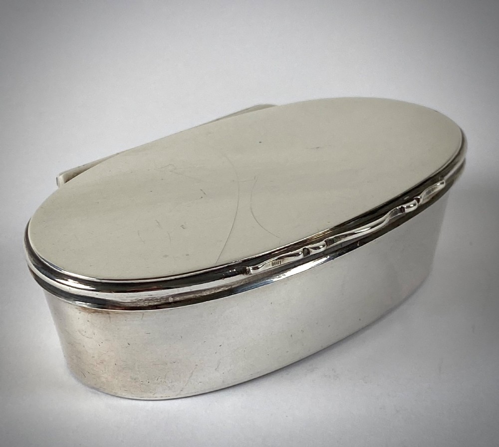 An open oval sterling silver snuff box displaying a gilded interior and hallmarks inside the lid. View II