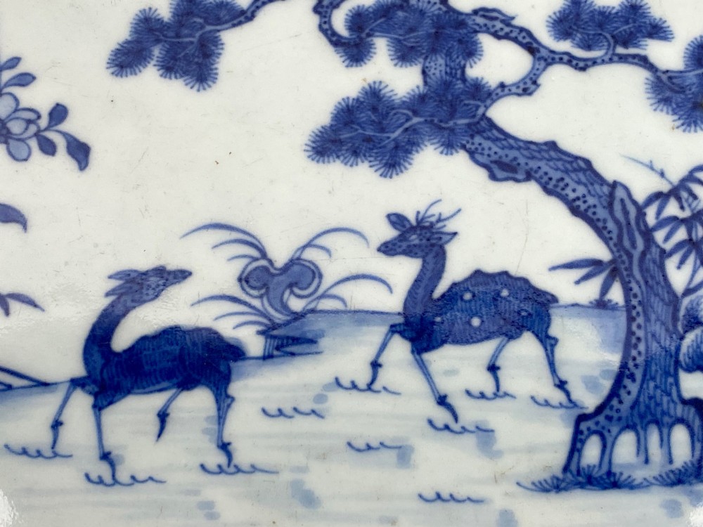 An 18th-century octagonal Chinese export porcelain platter painted in underglaze cobalt blue with a central scene of two deer under a pine tree surrounded by a patterned border. View II