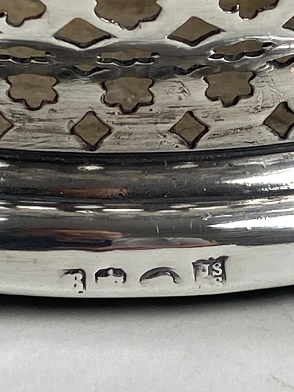 A pair of Georgian sterling silver wine coasters with pierced fretwork, grapevine rims, and dark wooden bases. View V