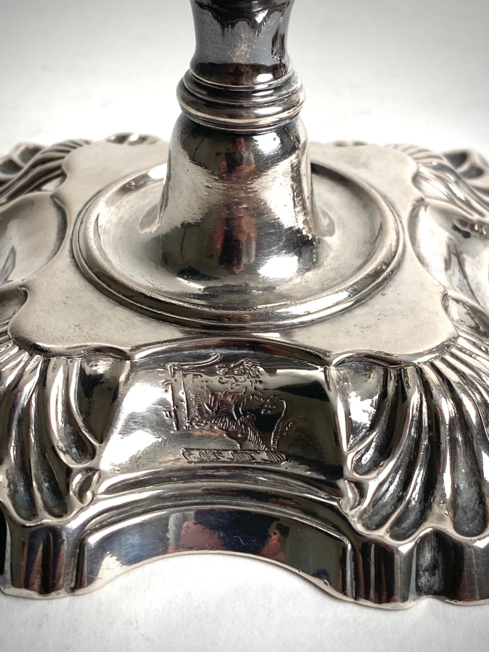 A pair of Georgian sterling silver candlesticks featuring shell-cast stepped bases and baluster stems. View II