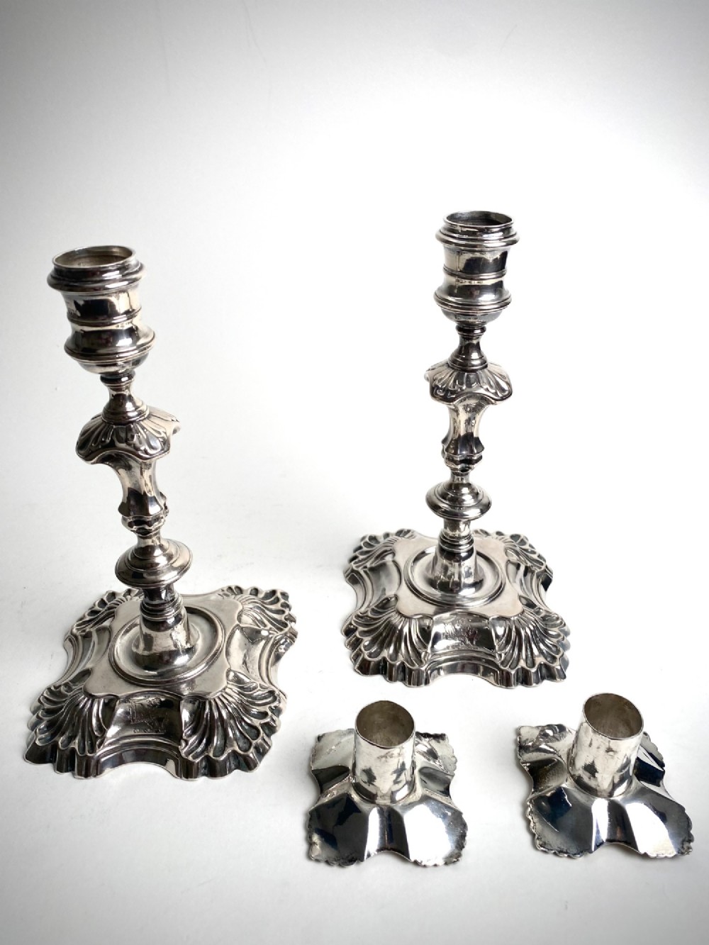 A pair of Georgian sterling silver candlesticks featuring shell-cast stepped bases and baluster stems. View III