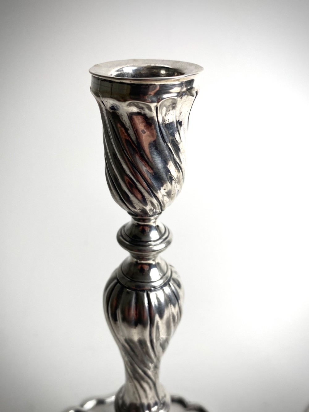 A pair of polished sterling silver candlesticks featuring spiral-twisted stems and wide, lobed flared bases. View II