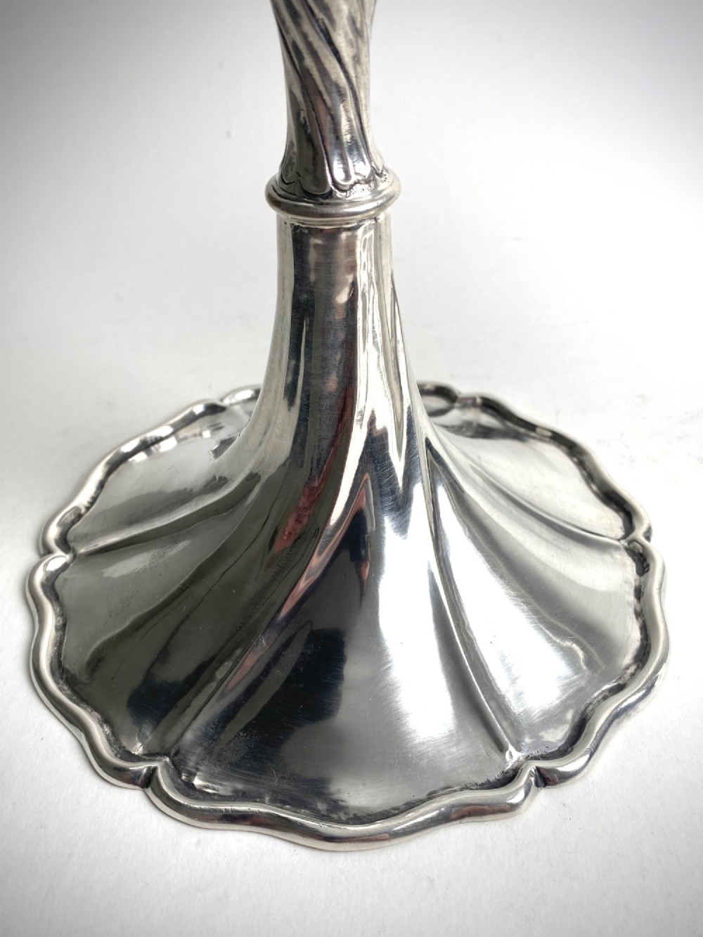 A pair of polished sterling silver candlesticks featuring spiral-twisted stems and wide, lobed flared bases. View IV