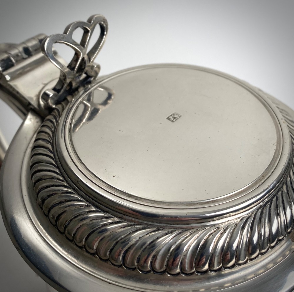 A sterling silver lidded tankard featuring spiralled fluted ornamentation along the lower body, gadrooned borders, a scroll handle, and stamped hallmarks. View IV