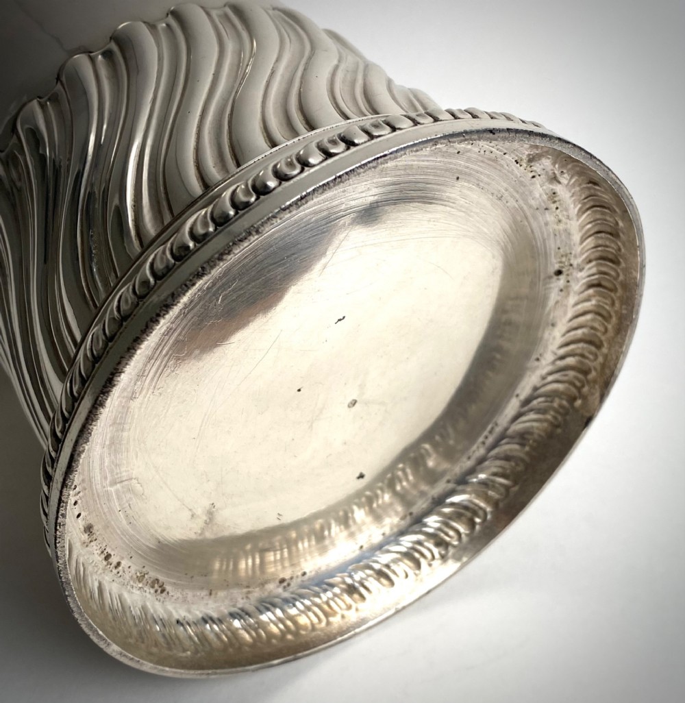A sterling silver lidded tankard featuring spiralled fluted ornamentation along the lower body, gadrooned borders, a scroll handle, and stamped hallmarks. View VI