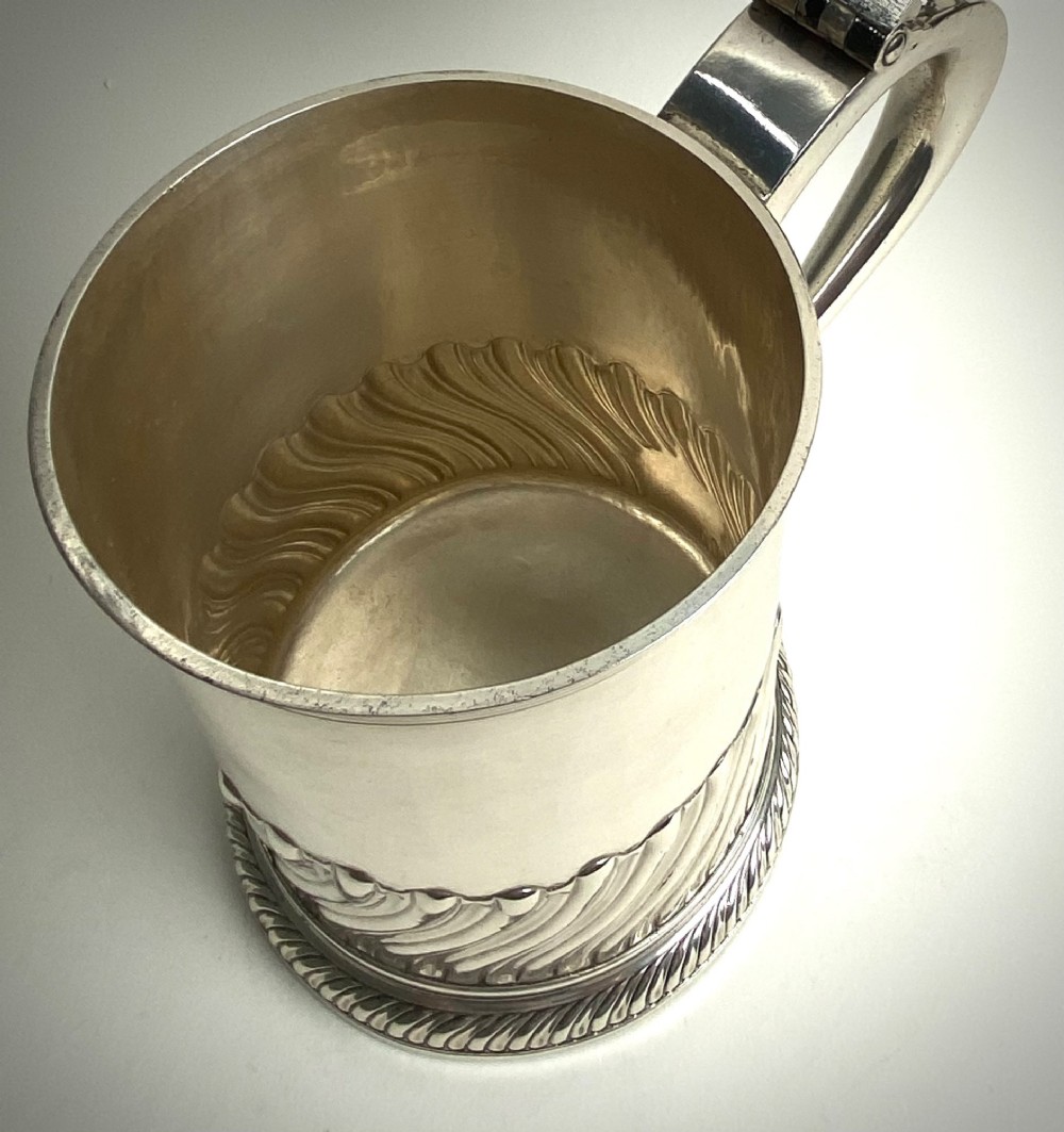 A sterling silver lidded tankard featuring spiralled fluted ornamentation along the lower body, gadrooned borders, a scroll handle, and stamped hallmarks. View VII