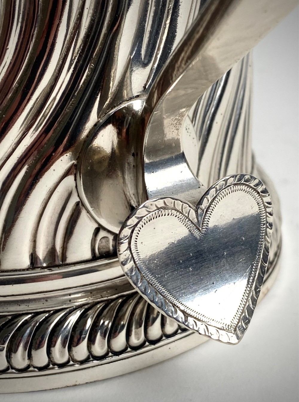 A sterling silver lidded tankard featuring spiralled fluted ornamentation along the lower body, gadrooned borders, a scroll handle, and stamped hallmarks. View VIII