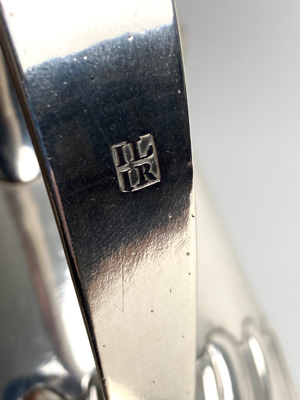 A sterling silver lidded tankard featuring spiralled fluted ornamentation along the lower body, gadrooned borders, a scroll handle, and stamped hallmarks. View IX