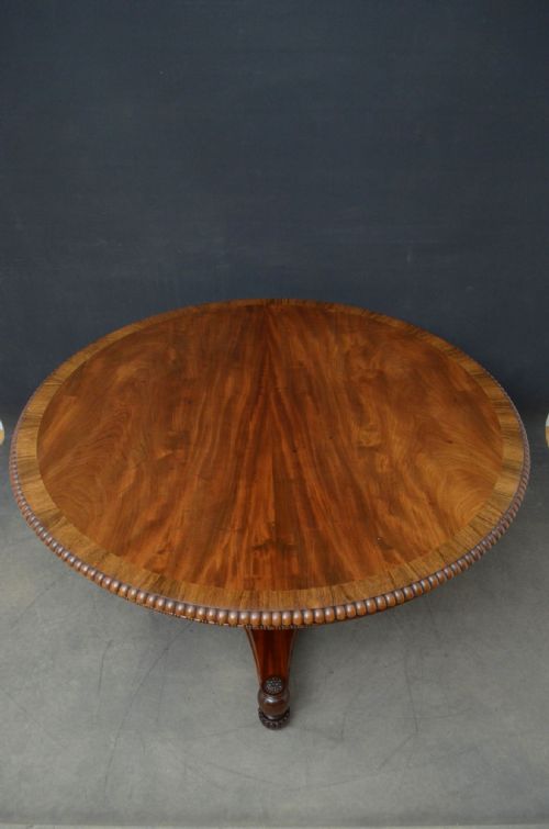 fig 1. A circular Regency mahogany centre table featuring flame mahogany veneer, a reeded edge, and a fluted central pedestal column on a triform base.