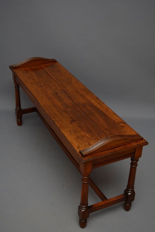 fig 1. An antique brown walnut hall bench featuring turned legs, an H-stretcher, and raised curved side handles.