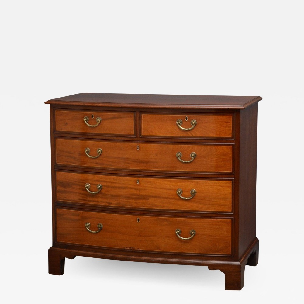 A Regency mahogany chest of drawers featuring two short drawers over three long graduated drawers with brass drop handles and bracket feet.