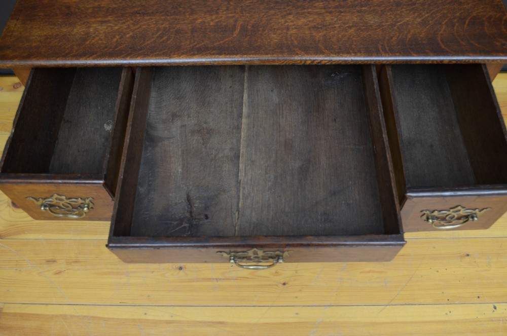 An 18th-century George II oak lowboy table featuring three drawers with decorative brass handles, a shaped lower apron, and four cabriole legs with pad feet. View VIII