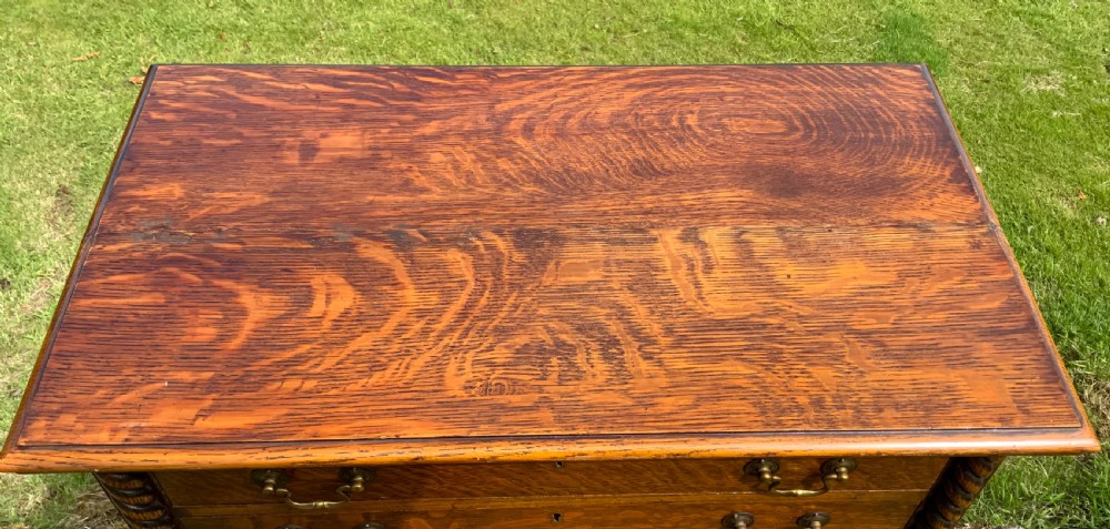 A late Victorian oak tall chest featuring six drawers flanked by barley twist columns resting on turned legs with a open bottom shelf. View III