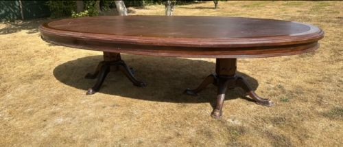 A large Edwardian oval mahogany boardroom table featuring a brown leather inset top supported by twin pedestal legs with splayed feet. View III