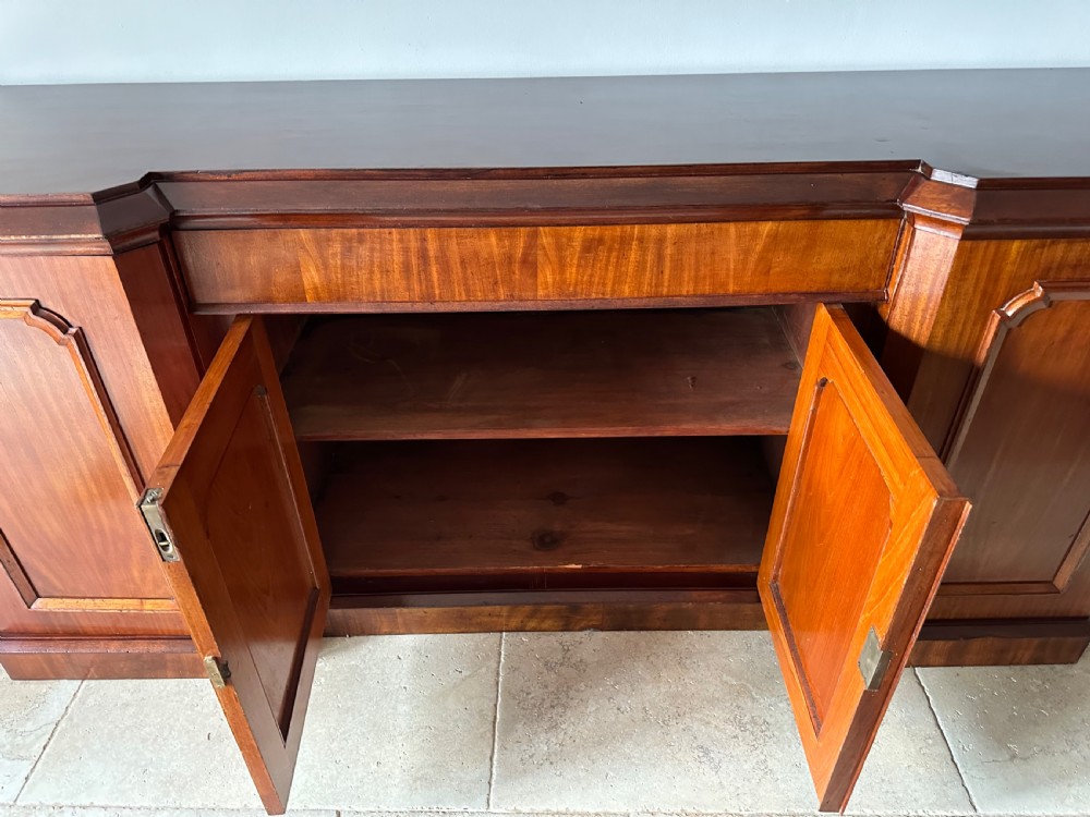A nineteenth-century Victorian mahogany breakfront sideboard featuring four moulded panel doors and a polished wooden top. View II