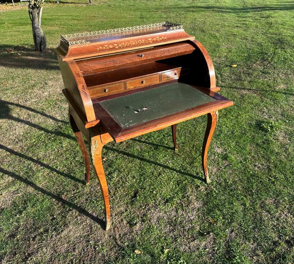 A 19th-century French cylinder roll-top desk crafted with floral marquetry inlays, slender cabriole legs, and brass ormolu mounts. View IV