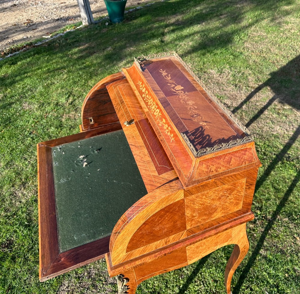 A 19th-century French cylinder roll-top desk crafted with floral marquetry inlays, slender cabriole legs, and brass ormolu mounts. View VI